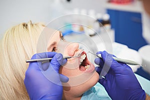 Dentist checking bracket at the braces on the female patient. Close-up. Real People.