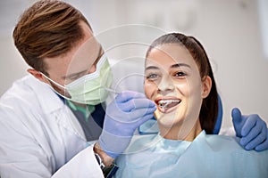 Dentist checking up femaleâ€™s teeth