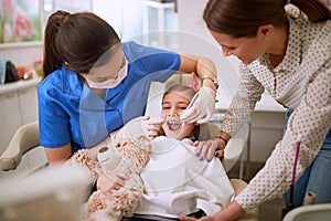 Dentist checking up girlâ€™s teeth