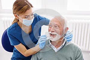 Dentist checking up patient at dental clinic