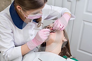 Dentist checking up patient teeth with metal braces at dental clinic office. Medicine, dentistry and health care concept