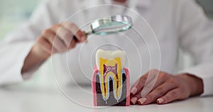 Dentist checks oral cavity and teeth using magnifying instrument