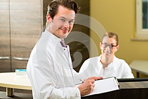 Dentist with clipboard in his surgery