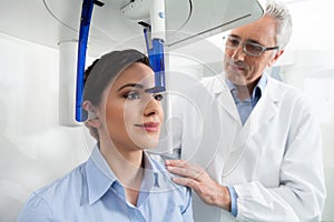 A dentist controlling his female patient before an x-ray panoramic digital photo
