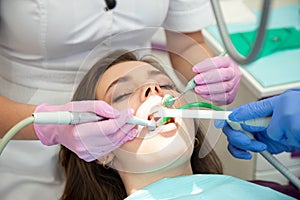 Dentist curing carious tooth of female patient in dental office clinic.