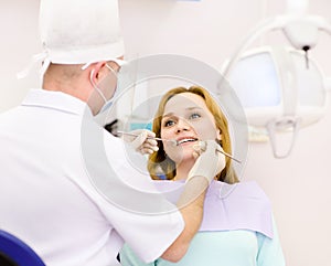 Dentist curing a girls teeth in the dental office photo