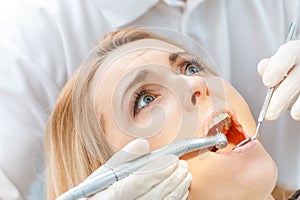 Dentist curing scared patient looking up