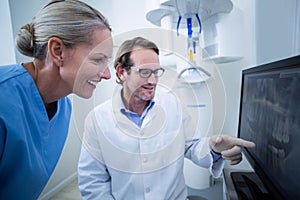 Dentist and dental assistant discussing a x-ray on the monitor