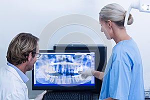 Dentist and dental assistant discussing a x-ray on the monitor