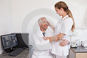 Dentist and dental assistant embracing inappropriately