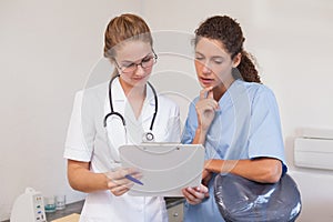 Dentist and dental assistant looking at clipboard