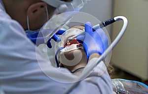 A dentist with dental instruments, a professional doctor drills his patient`s teeth