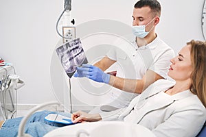 Dentist discussing dental x-ray scan with woman in clinic