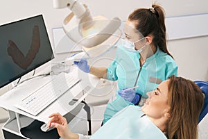 Dentist discussing results of dental 3D scanning with woman in clinic