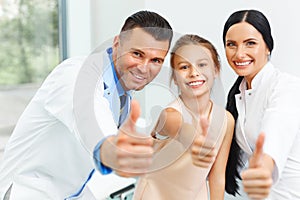 Dentist doctor, assistant and little girl all smiling at camera
