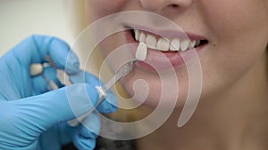 Dentist doctor checking whiteness of patient teeth