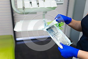 Dentist doctor opening sealed sterile dental instruments.