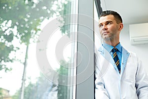 Dentist Doctor Stands Near Window and Thinks about Clinic Future