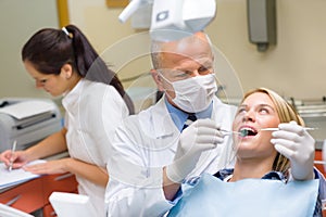 Dentist doing procedure on young patient woman