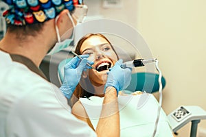 Dentist examine female patient with braces in denal office. photo