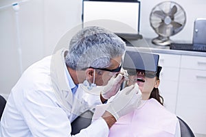 Dentist examine female patient with dental tools