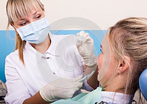 Dentist examines the oral cavity on tooth decay.