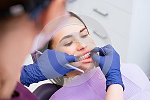 The dentist examines the patients bite at the dental office photo