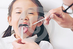 Dentist examining child teeth in dental clinic.