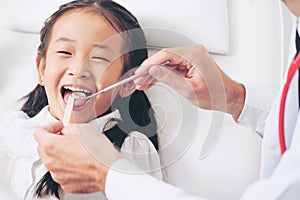 Dentist examining child teeth in dental clinic.