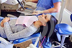 Dentist examining female`s teeth in dentistry.