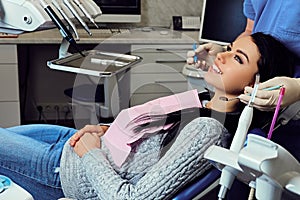 Dentist examining female`s teeth in dentistry. photo