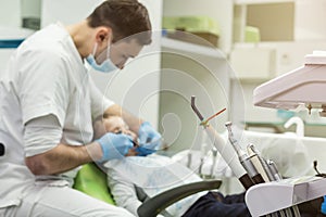 Dentist examining little boy`s teeth in clinic. Dental problem.