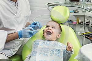 Dentist examining little boy`s teeth in clinic. Dental problem.