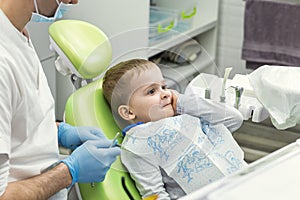 Dentist examining little boy`s teeth in clinic. Dental problem.