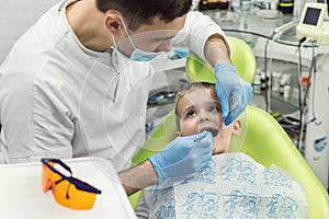 Dentist examining little boy`s teeth in clinic. Dental problem.