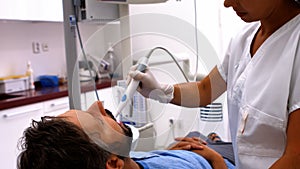 Dentist examining male patient with tools