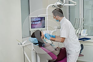 Dentist examining patient`s teeth with intraoral camera