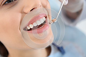 Dentist examining patient`s teeth in modern clinic