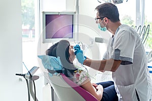 Dentist examining patient teeth with intraoral camera