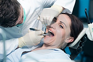 Dentist examining Patient teeth with a Mouth Mirror.