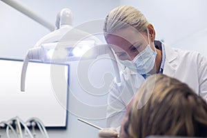 Dentist examining a patient with tools