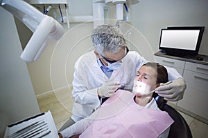 Dentist examining a patient with tools