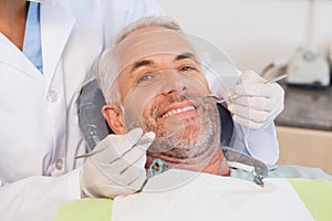 Dentist examining a patients teeth in the dentists chair photo