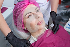 Dentist examining teeth of a young woman patient in a dental clinic.