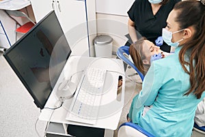 Dentist examining woman teeth with dental intraoral 3D scanner