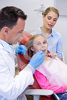 Dentist examining with young patient