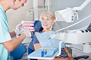 Dentist explaining to patient correct tooth brushing