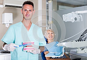 Dentist explaining tooth brushing on dental model