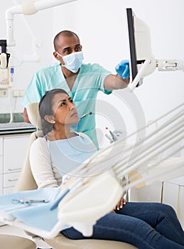 Dentist explaining treatment to female patient in dental clinic