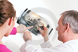 Dentist explaining x-ray to patient photo